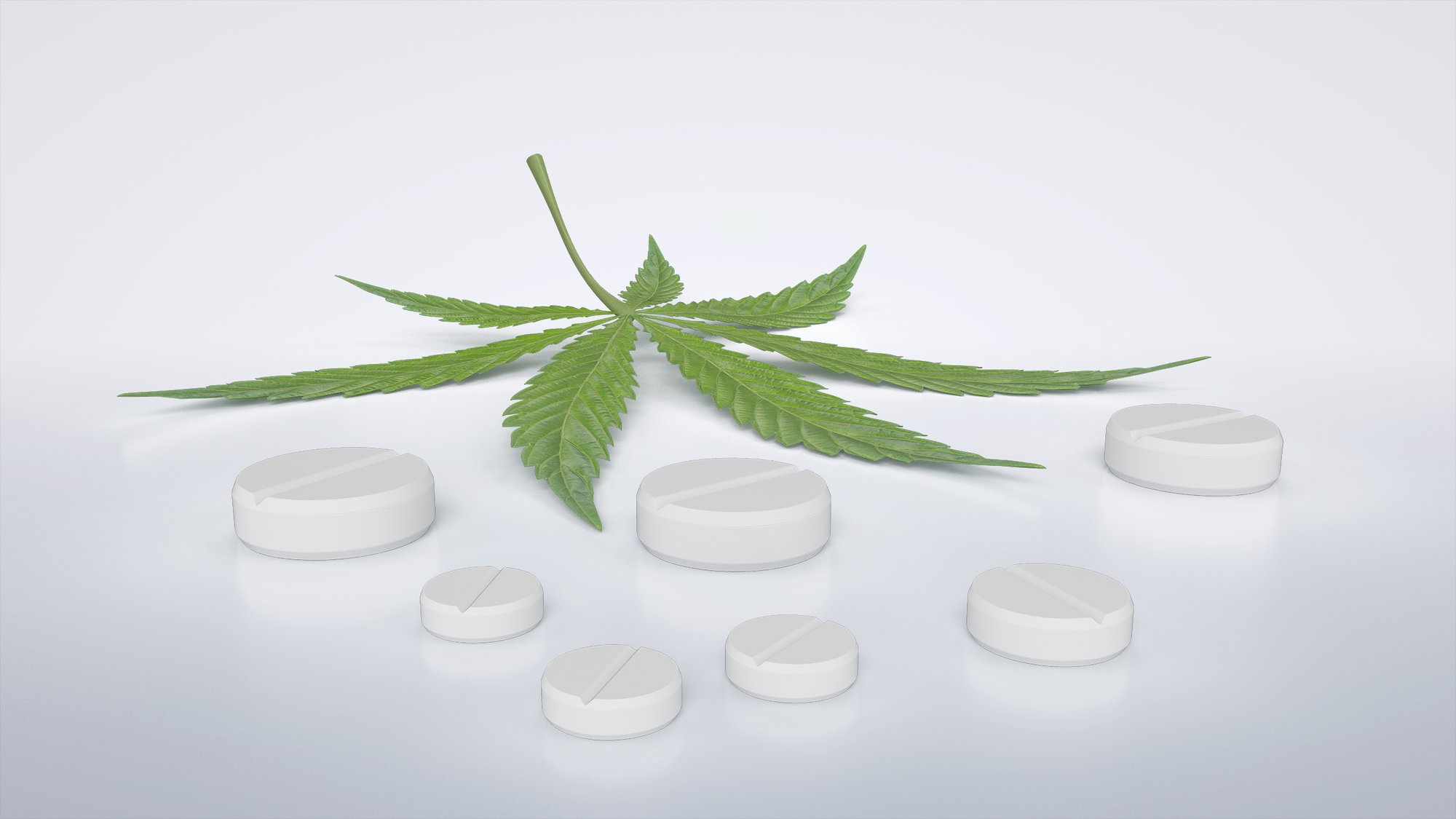 White nutraceutical tablets arranged around a cannabis leaf.