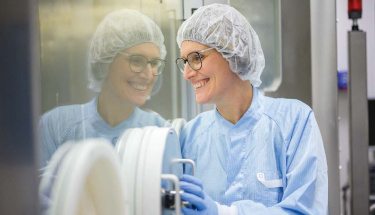 Ein Pharmafachmann im sterilen Kittel bedient RTU-Geräte und demonstriert die Einhaltung der GMP- und Annex 1-Standards für eine sichere Produktion durch Syntegon.
